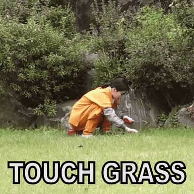Person Kneeling in Grass Saying Touch Grass