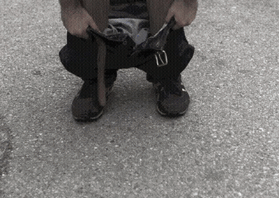 Person Kneeling With Pants Down And Belt GIF