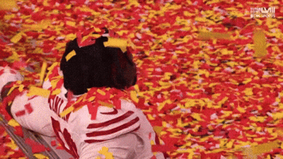 Person Laying In Confetti With Letters LM GIF