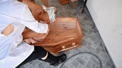 Person Laying In Wooden Coffin With Head Bandage GIF