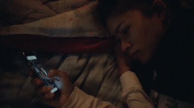 Person Laying On Bed Looking At Phone GIF