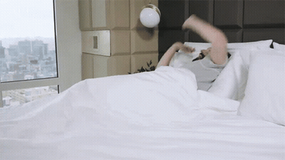 Person Laying On Bed With City View GIF