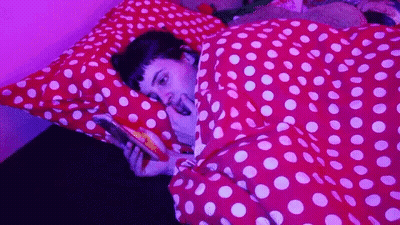 Person Laying On Bed With Polka Dot Blanket GIF