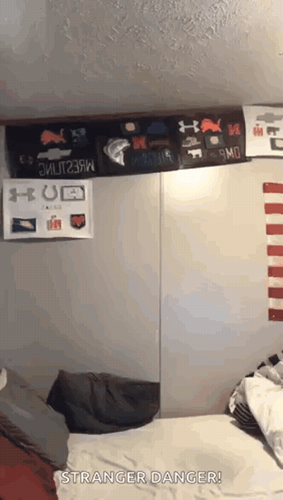 Person Laying On Bed With Stranger Danger Sign GIF