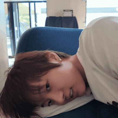 Person Laying On Blue Couch With Pillow GIF