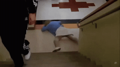 Person Laying On Floor In Front Of Red Cross GIF