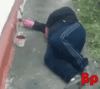 Person Laying On Ground Painting Wall With BP GIF