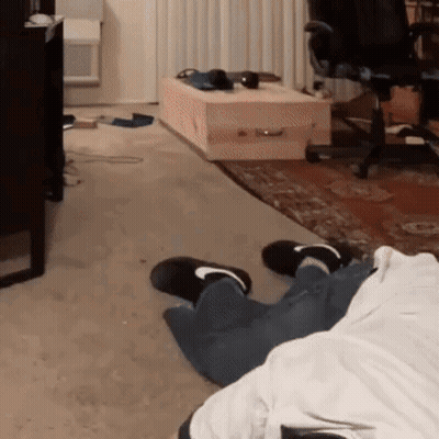Person Laying On Living Room Floor With Coffin GIF