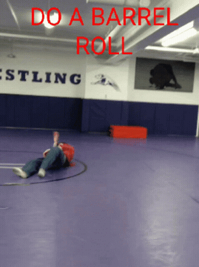Person Laying On Wrestling Gym Floor Saying Do A Barrel Roll GIF