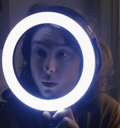 Person Looking In Mirror With Ring Light GIF