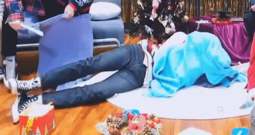 Person Lying Cross-Legged Near Christmas Tree GIF