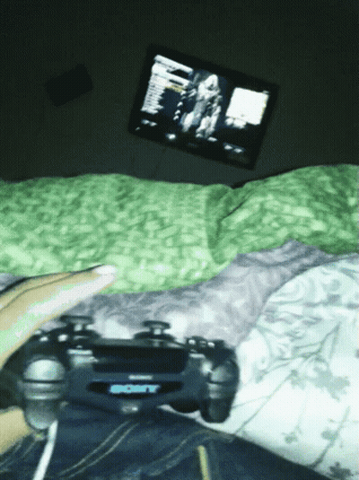 Person Lying On Bed Playing Video Game With Sony Controller GIF
