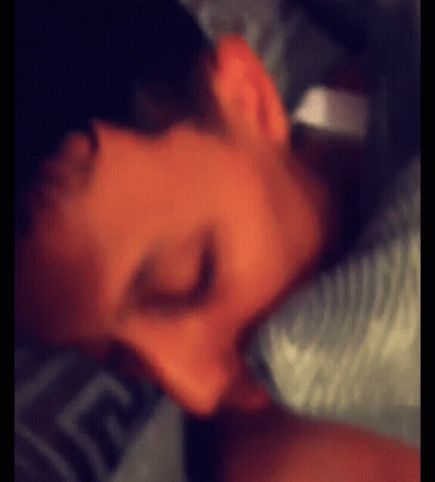 Person Lying On Bed With Greek Key Sheets GIF