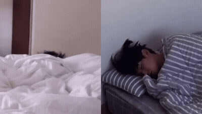 Person Lying On Bed With Striped Comforter GIF