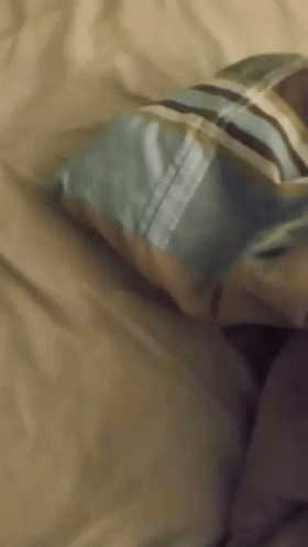 Person Lying On Bed With Striped Pillow GIF