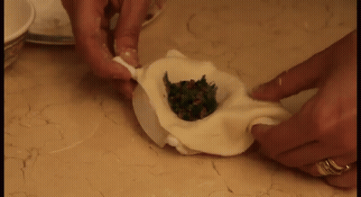 Person Making Dumpling With Ring On Left Hand GIF