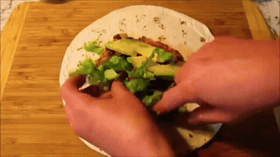 Person Making Tortilla With Lettuce Avocado And Meat GIF
