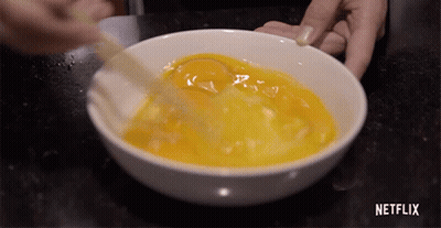 Person Mixing Eggs In Bowl With Netflix Logo GIF