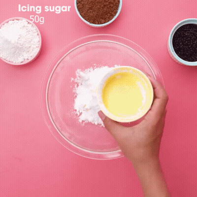 Person Mixing Icing Sugar In Glass Bowl GIF