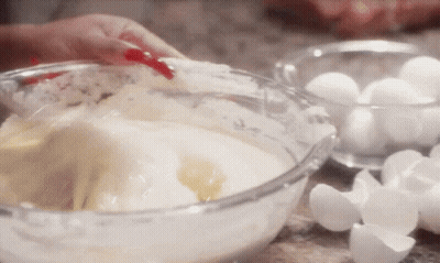 Person Mixing Ingredients In Glass Bowl With Eggs GIF