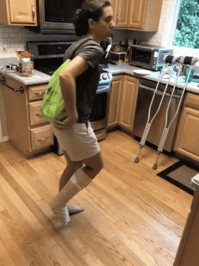 Person On Crutches With Green Bag In Kitchen GIF