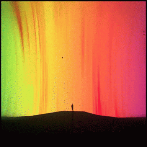 Person On Hill In Front Of Rainbow Sky GIF