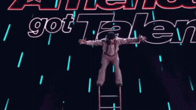 Person On Ladder In Front Of Got Talent Sign GIF
