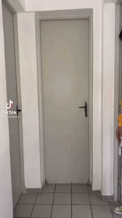 Person Opening Door In Tiled Hallway GIF