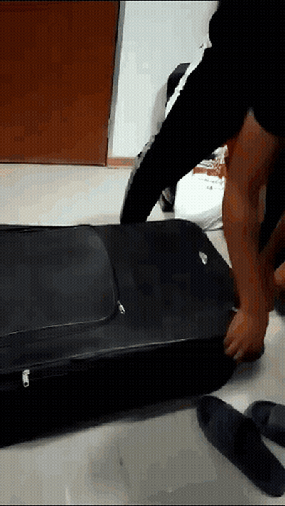 Person Packing Suitcase With Zipper
