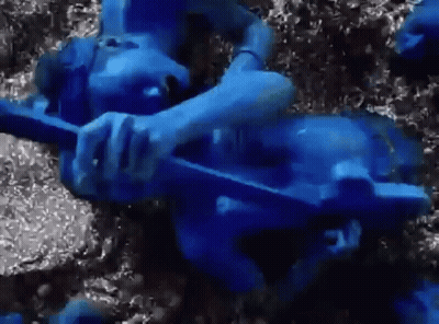 Person Painted Blue Laying On Ground GIF