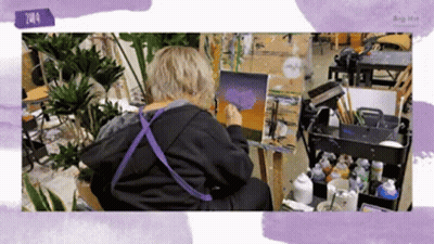 Person Painting On Easel In Purple Apron GIF