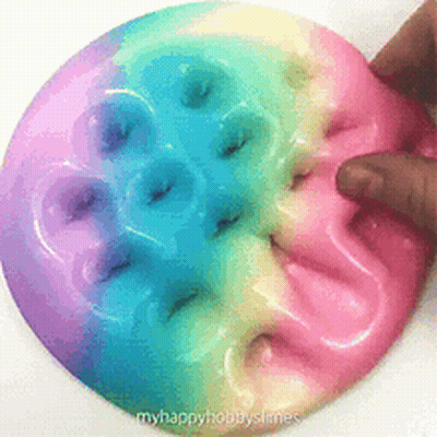 Person Playing With Rainbow Slime Donut GIF
