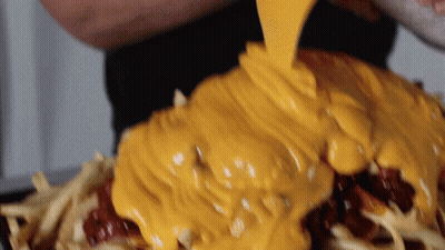 Person Pouring Cheese On Pile Of Food GIF