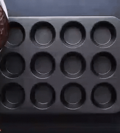 Person Pouring Chocolate Into Cupcake Pan GIF