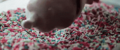 Person Pouring Chocolate On Sprinkles GIF