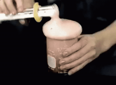 Person Pouring Liquid Into Beaker With Lemon Slice GIF