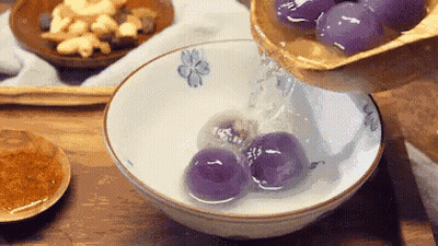 Person Pouring Liquid Into Bowl Of Purple Balls GIF