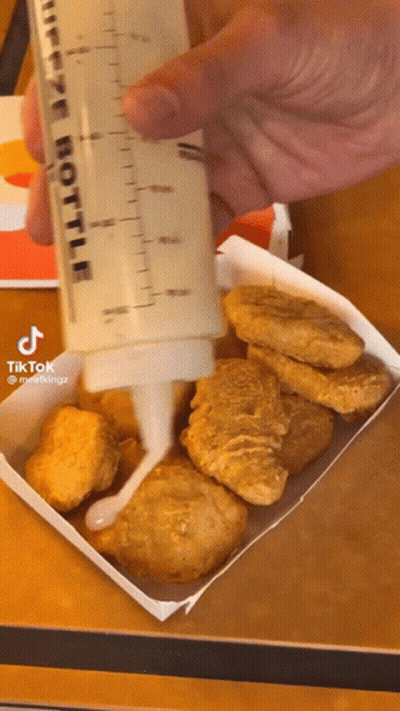 Person Pouring Sauce Into Chicken Nuggets GIF