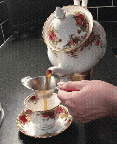 Person Pouring Tea From Teapot Into Cup GIF