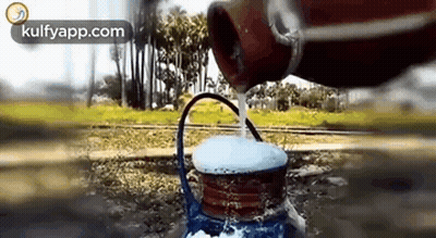 Person Pouring Water From Bottle Into Teapot GIF