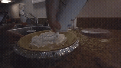 Person Pouring Whipped Cream Into Pie GIF