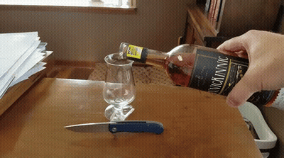 Person Pouring Wine Into Glass With Knife GIF