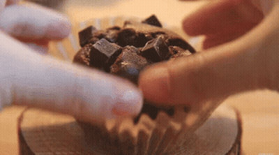Person Putting Chocolate Chips In Chocolate Cupcake GIF