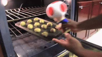 Person Putting Cookies In Oven With Toad GIF