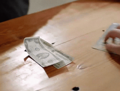 Person Putting Dollar Into Piggy Bank GIF
