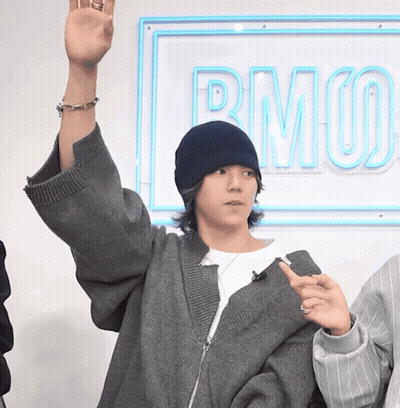 Person Raising Hand By Neon Sign Saying Rmuo GIF
