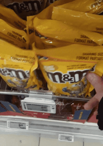 Person Reaching For Bag Of M&M's GIF