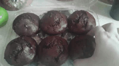Person Reaching For Chocolate Muffin In Plastic Container GIF