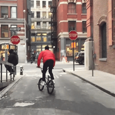 Person Riding Bike At Stop Sign GIF