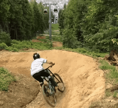 Person Riding Bike Down Dirt Trail GIF